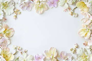 Fototapeta na wymiar White paper adorned with a delicate flower frame in soft pastel hues