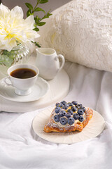 Morning breakfast with buns with cream, berries, fruits on a white tray. Breakfast in bed.