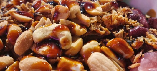 Delicious close-up of homemade peanut brittle with caramelized sugar, nuts, and a crunchy texture, perfect for a sweet indulgent treat or gourmet dessert