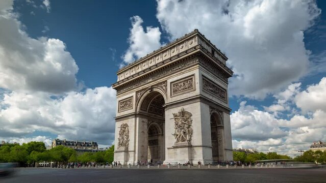 PARIS, FRANCE - FEBRUARY 20, 2024: Timelapse motion hyperlapse view of the Arc de Triomphe (Triumphal Arch of the Star) with traffic on circle road. Famous monument and touristic landmark in Paris.
