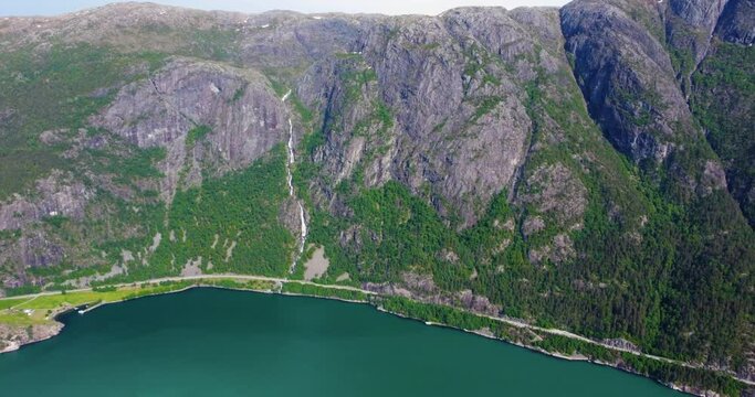 Aerial panning view, waterfall flowing down mountain side. Tourism in Iceland. Inspiration in nature. Langfoss waterfall