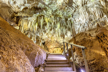 Staircase for visitors in Prometheus Cave Natural Monument in Georgia with stalactites and...