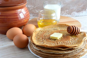 plate with pancakes and piece of butter close up