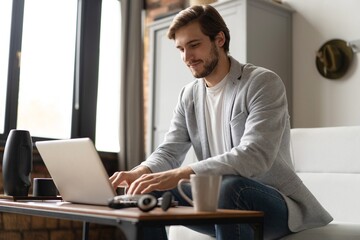 Businessman working with laptop from home sitting at table.