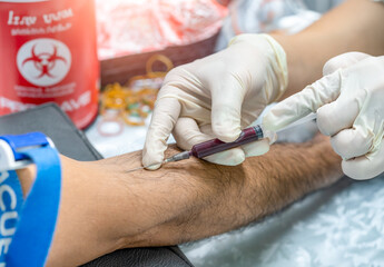 Close up hand of nurse, taking blood sample from a patient in the hospital.