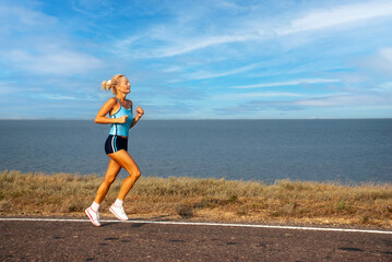 Girl running along the seashore - 745237125