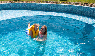 Little boy with sister in the pool during vacation - 745237176