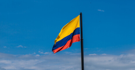 vandera del pais de colombia sobre un fondo del cielo azul 