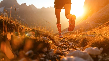 Foto op Canvas Trail runner's legs in motion on a mountain path at sunset, with a dramatic alpine background. © Kowit