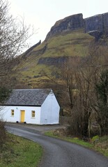 Cottage house at foot of cliff face in rural County Leitrim, Ireland