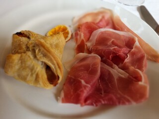 Delectable italian starter featuring sliced prosciutto ham and golden-baked focaccia bread