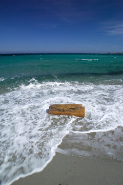 beach and sea Trunk at the mercy of the surf on Budoni beach. OT, Sardinia, Italy