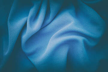 A crumpled blue fabric background. Close up.