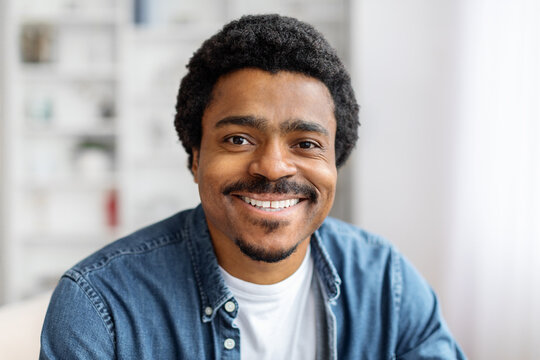Portrait of cheerful young black man smiling at camera