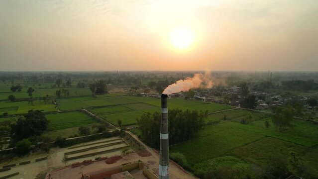 Aerial drone shot of a brick kiln factory where they are baking clay into bricks used for construction at sunset
