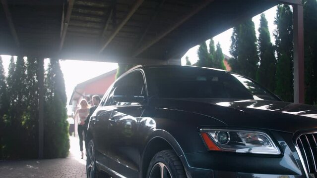 The husband and wife are late for the meeting. The couple hurriedly gets into their car and drives away. A handsome man assists his beautiful young wife into the car. They were late for a work meeting