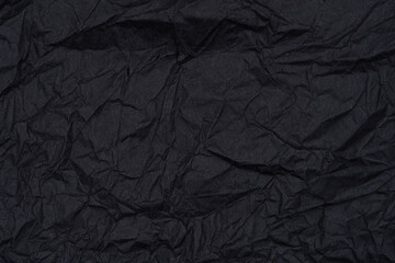 Close-up of a crumpled black paper texture.