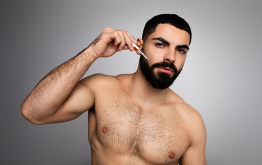 Attractive arab guy using hair growth for his beard
