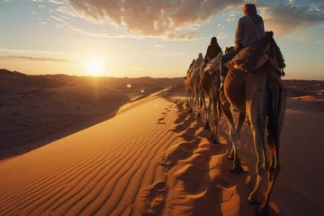 Foto op Canvas Tourists on Dromedary Camels Traversing the Sahara Desert at Sunset with Tour Guide Leading the Way © bomoge.pl