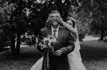 newlyweds groom wait sees bride. girl closes guy eyes with her hands