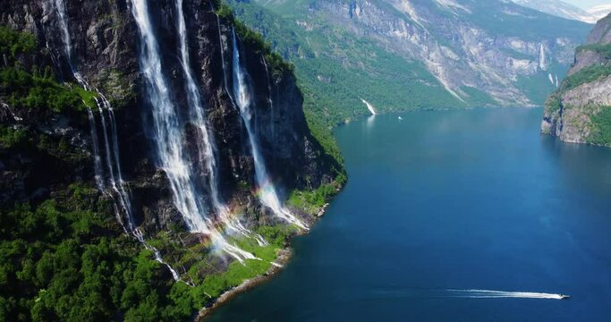 Seven Sisters waterfall in Norway Geirangerfjord. A vibrant rainbow enhances the scene on a sunny day, inviting viewers to explore this breathtaking destination.  4k. travel concept