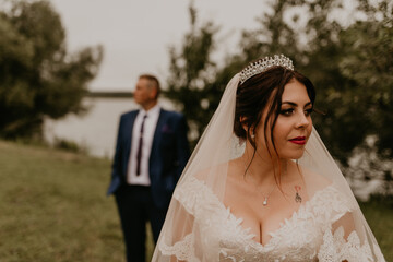 newlyweds look in different directions. man stands behind woman