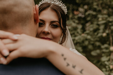 bride hugs groom arm tattoo in the form of flying birds swallows