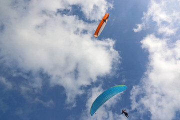 Paragliders flying in a blue sky	