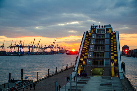 HAMBURG, GERMANY - March 5th, 2022: Elbe river, Harbor sunset scenery, View to the office building "Dockland" in the district Altona