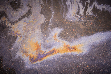 Textured stain of fuel or oil on wet asphalt on a rainy day. The concept of environmental pollution