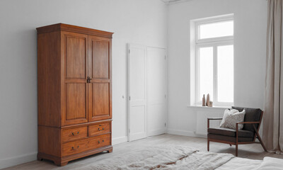 A spacious white wardrobe integrates seamlessly into a bedroom with pristine walls, accented by natural textures and subtle decor, creating a peaceful and harmonious space.