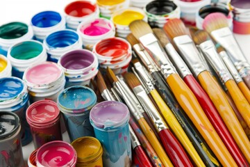 A collection of colorful paints and brushes spread out for an art project.