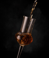 whiskey pouring into a glass on a black background