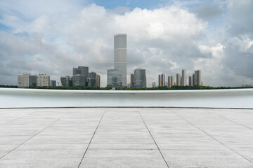 Fototapeta premium empty ground floor with modern cityscape and cloudy sky.