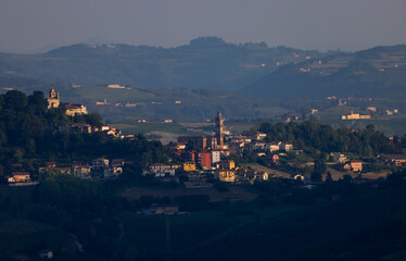 Fototapeta na wymiar typical piedmontese landscape with small villages and vines in sunrise light