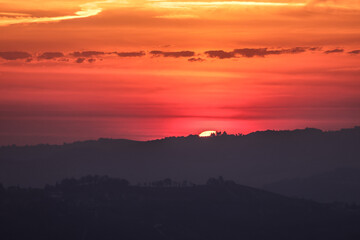 the sun rises behind a mountain range in Piedmont