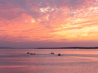 Pinky sunset at a lake and boats