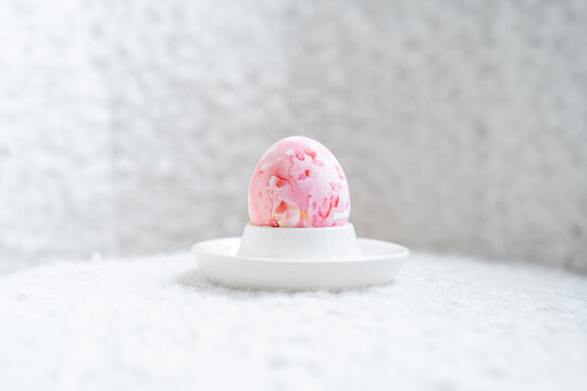 Close-up of a pink painted Easter Egg in an egg cup on a table