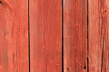 Red vertical wooden plank. Part of a wall.