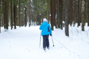 People ski in winter on a ski track through a winter forest.Cross Country skiing.