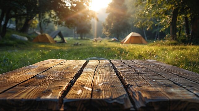 Wooden table top on blurry tent, tourist tent and grass field, refreshing and relaxing concept for product editing or important image layout design. View of the copy space