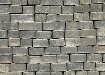 The surface of a wall or fence lined with gray bricks. Paving slabs of grey blocks of flat shape....