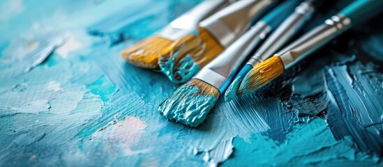Fototapeta premium This close-up shows three paint brushes neatly arranged on a wooden table, each showcasing different bristle styles and lengths. The table surface reflects the light, highlighting the details of the
