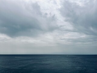 Naklejka na ściany i meble Cloudy seascape, sail boats silhouettes at the sea
