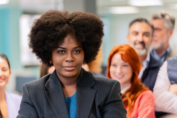 A confident businesswoman with a commanding presence leading a team discussion in an office. 