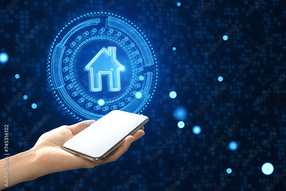 Poster Hand holding a smartphone controlling a glowing smart house icon on a digital binary background. Connectivity concept