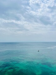 Cloudy seascape, sail boats silhouettes at the sea