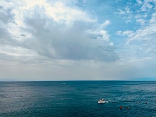 Fototapeta na wymiar Cloudy seascape, sail boats silhouettes at the sea
