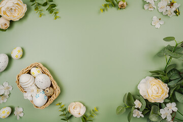 Happy Easter composition for easter design. Elegant Easter eggs with flowers on pastel green background. Flat lay, top view, copy space.