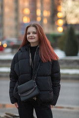 Obraz premium Portrait of a young beautiful long-haired girl on a spring city street.